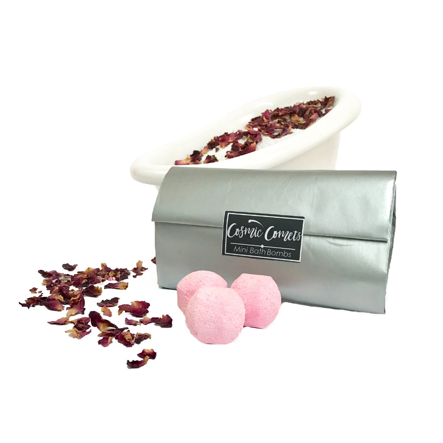 Cosmic Comets mini bath bombs placed next to a bath with rose petals, creating a colorful and relaxing spa atmosphere