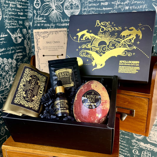 Fantasy dragon egg bath bomb gift set displayed in a keepsake box with bath bombs, crystals, charm bracelet, oil vial and wax-sealed letter arranged inside